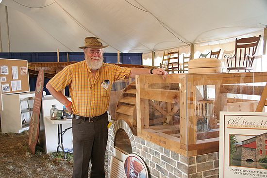 Art Shaw - the main organizer and display construction chief (and crew) for our IPM display stands beside his working model of the Old Stone Mill's waterwheel