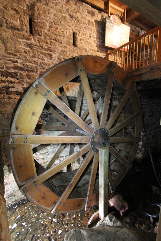 Old and new - the waterwheel got supplanted in the early 1860s by newer technology, turbines.  The turbines were located in purpose built addition to the mill, the turbine shed.  The slits in the stone wall that used to be the west wall of the mill and is now an inner wall between the mill and the turbine shed, are for belts from the two turbines to supply power into the mill.