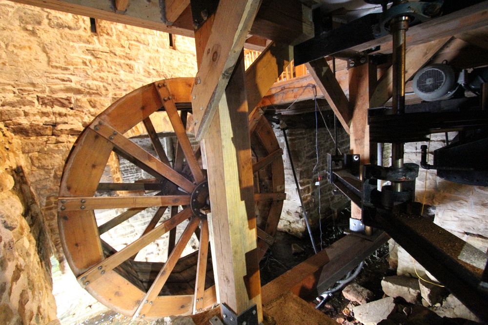 The hust is now centre left, the outer timber posts resting on a steel I-beam, the electric motor on the right.  This new husk was installed in 2010 for the mill's 200th anniversary.